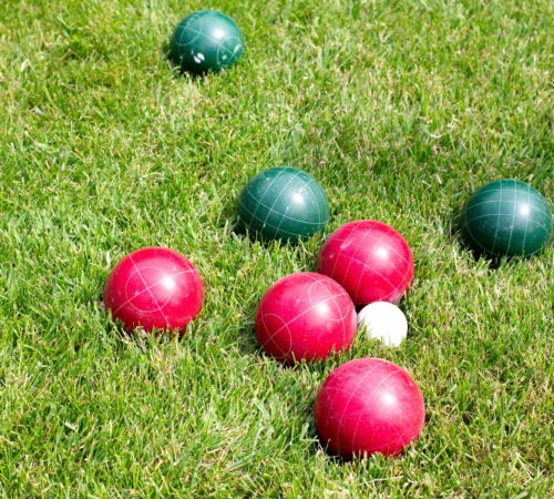 Red and green bocce balls in grass